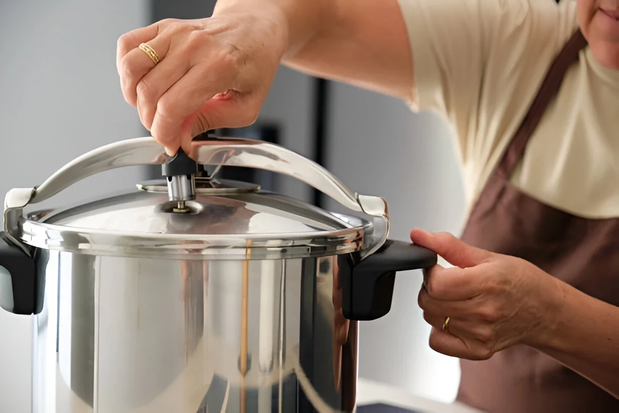 Panci presto (pressure cooker) sedang digunakan untuk memasak daging hingga empuk dengan uap bertekanan tinggi, menggambarkan teknik memasak presto yang lebih cepat dan efisien.
