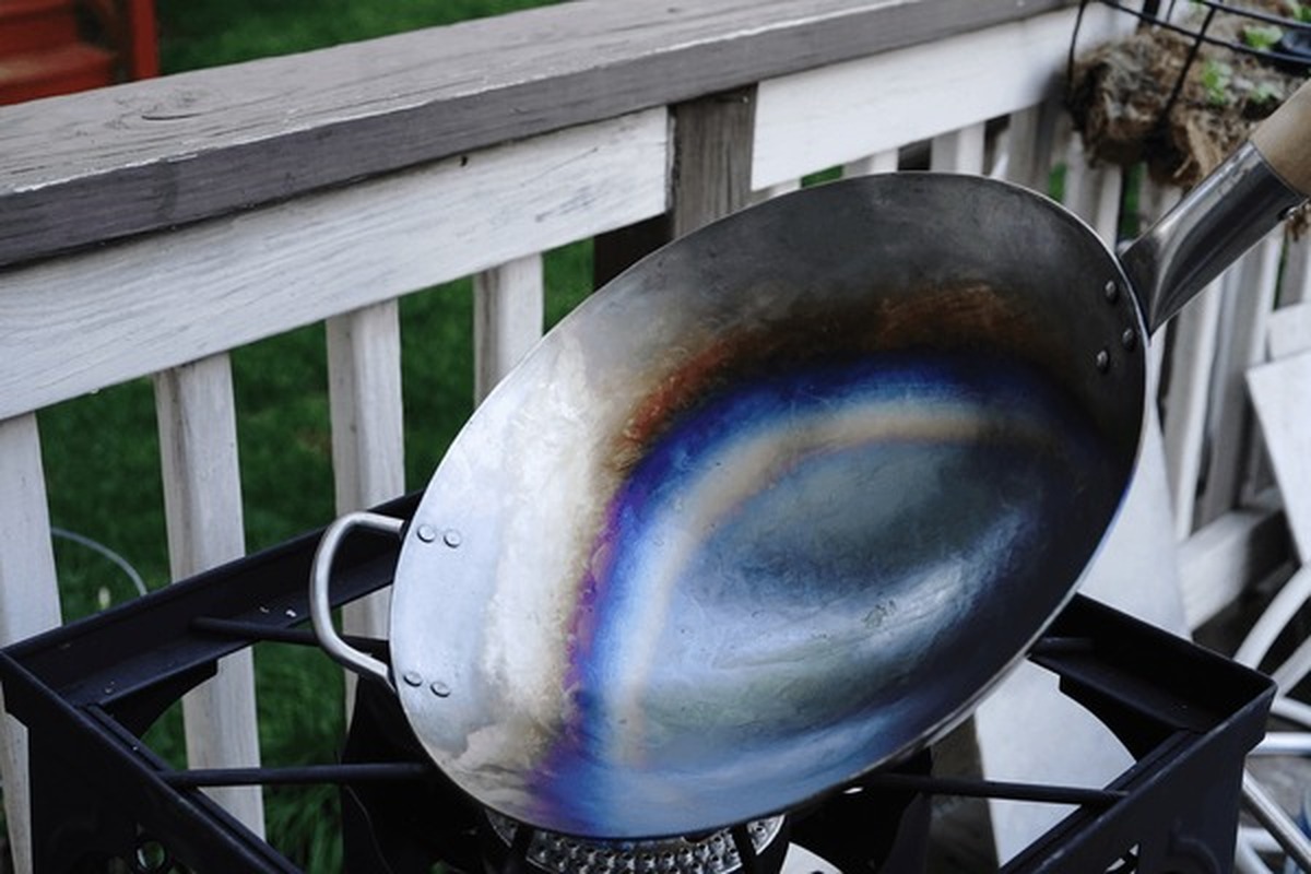 Proses seasoning wok dimana wajan dipanaskan sampai seluruh permukaan berubah warna