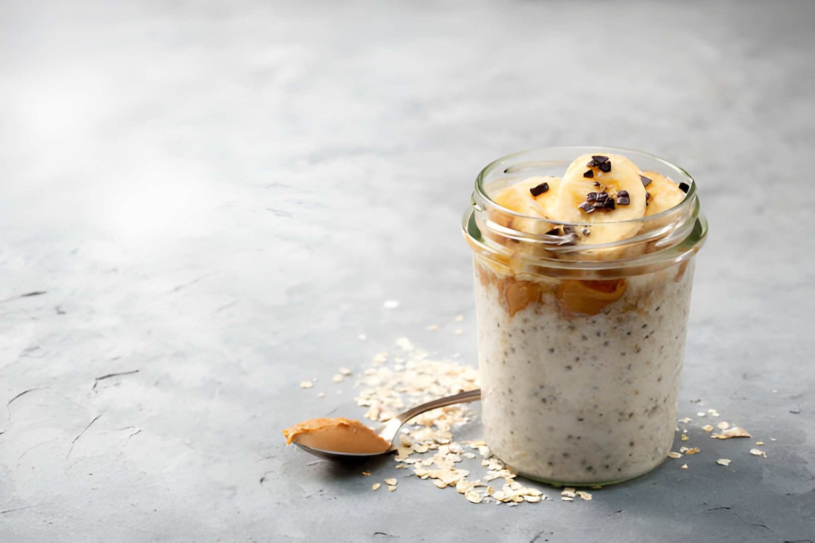 Overnight oats dalam stoples kaca dengan buah segar sebagai sarapan sehat kaya serat dan nutrisi.